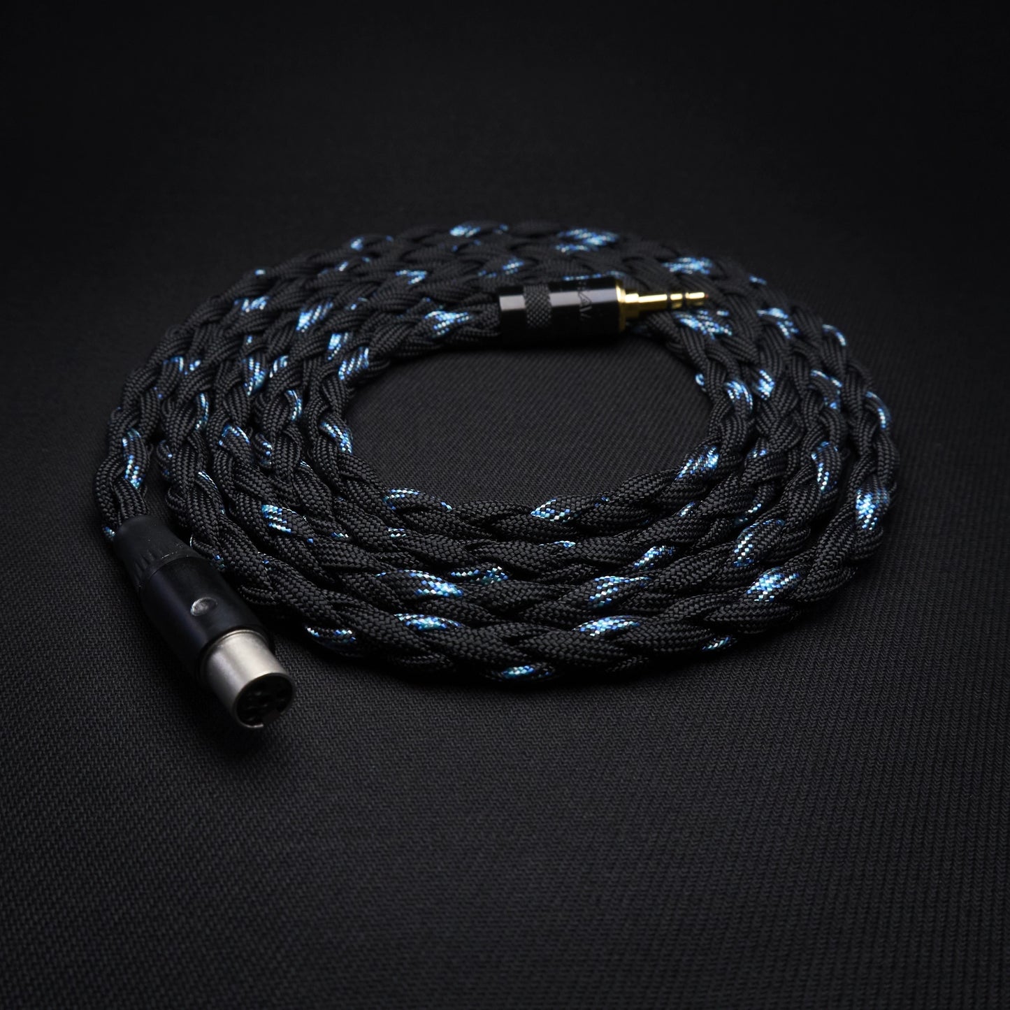 Braided audio cable with metallic connectors on a black background