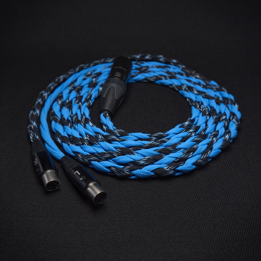 Braided blue and black audio cable on a dark background