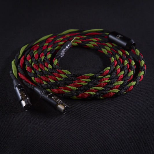 Braided audio cable with black, red, and green colors on a dark background