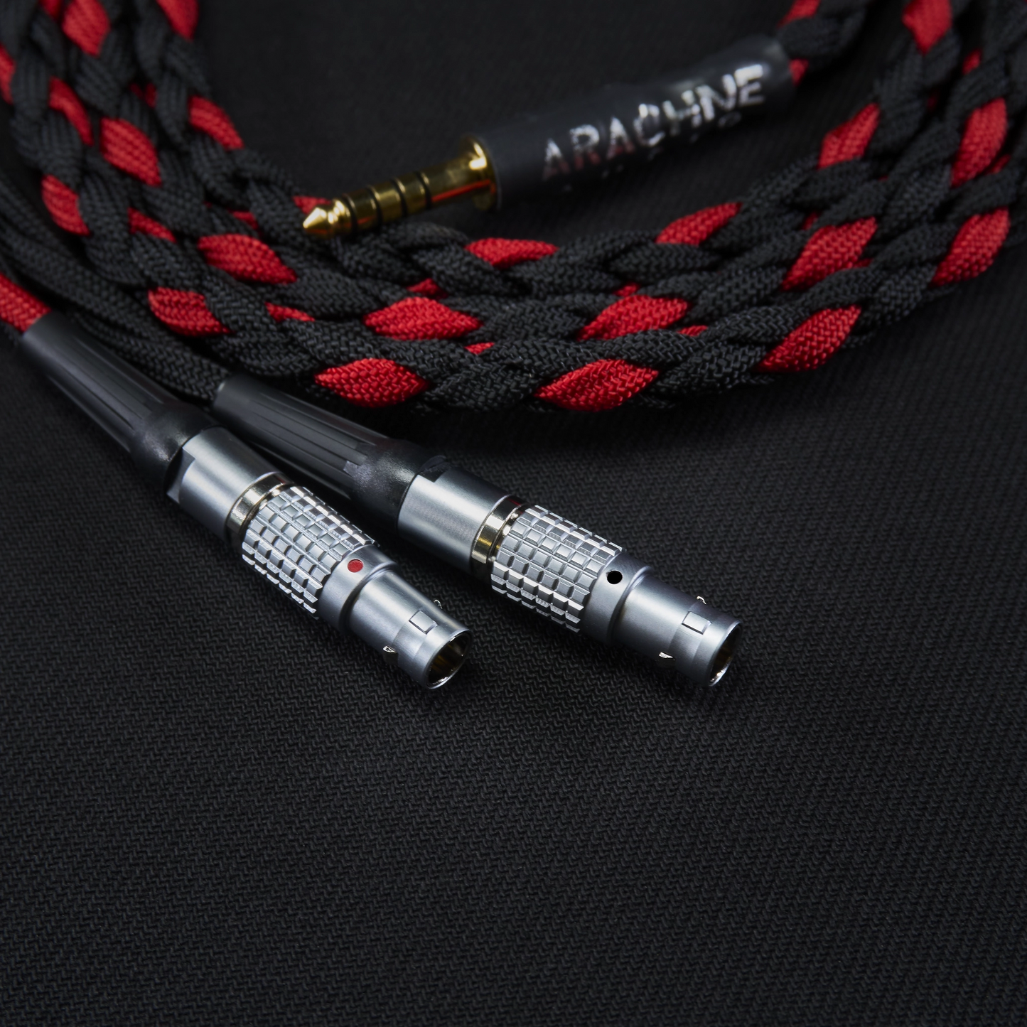 Braided audio cable with metal connectors on a black background