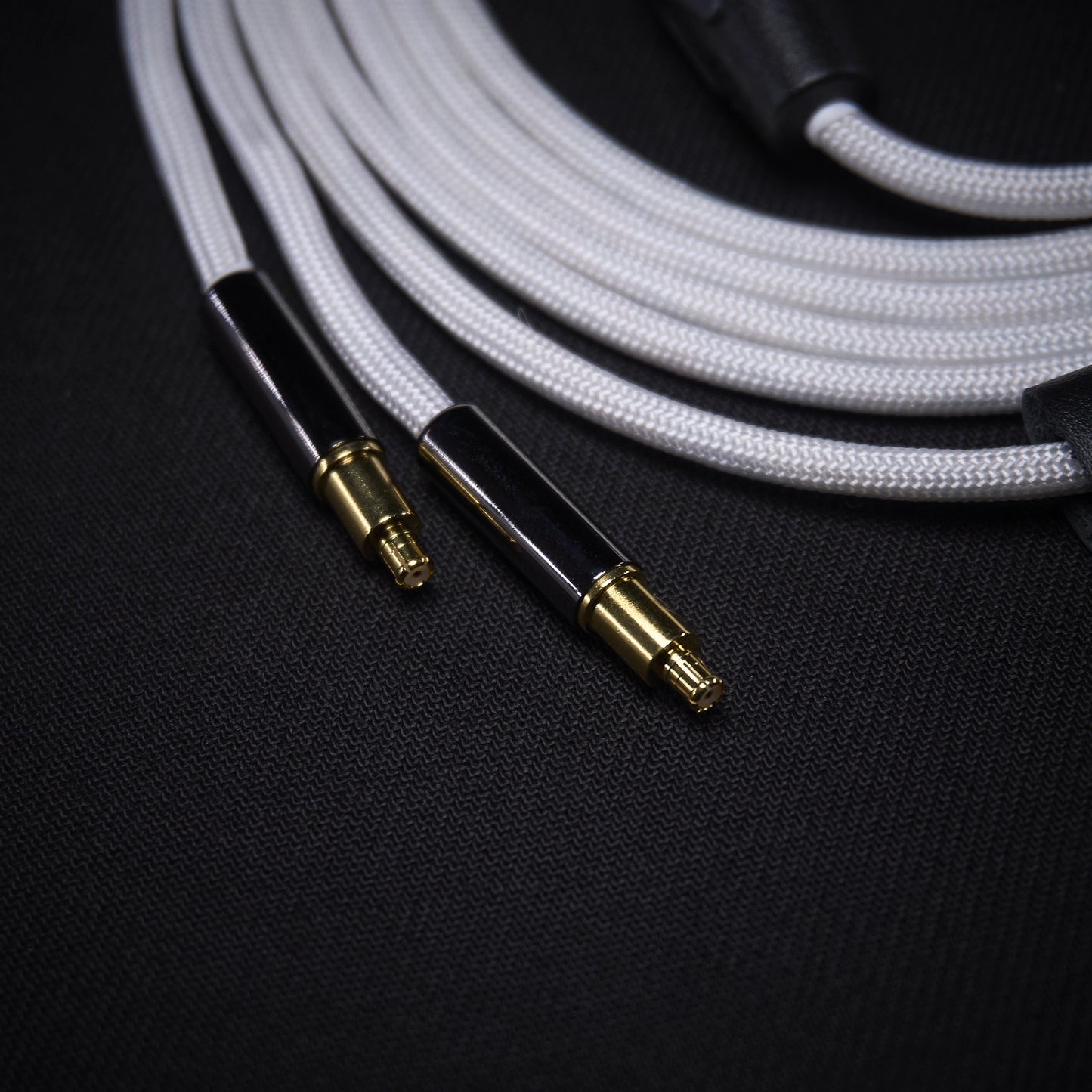 Close-up of audio cable with gold connectors on a dark background
