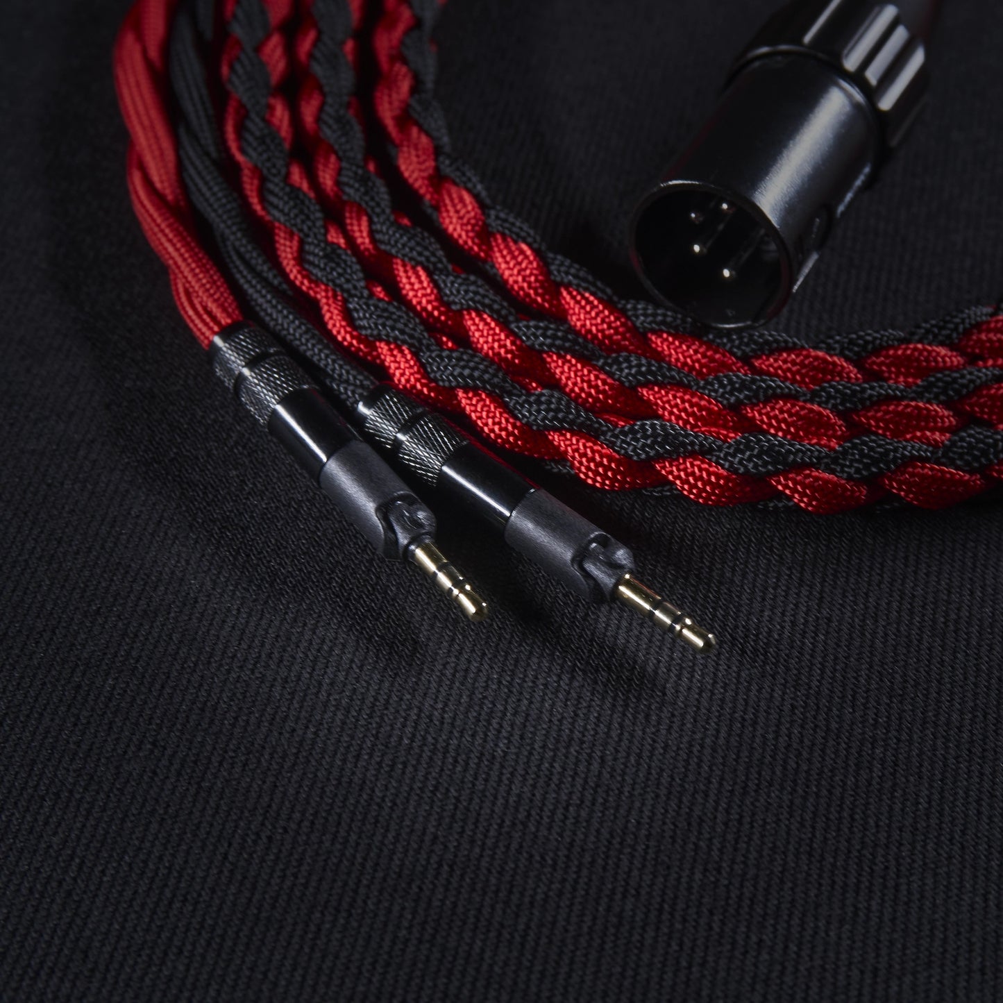Braided red and black audio cable with connectors on a black background