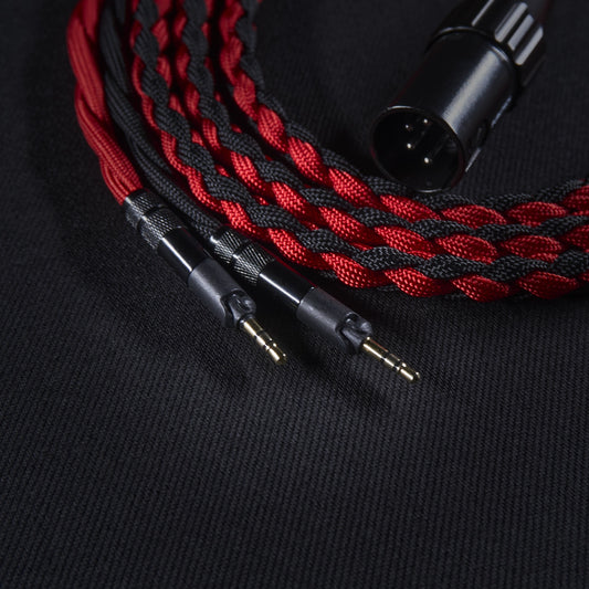 Braided red and black audio cable with connectors on a black background