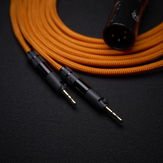 Orange audio cable with XLR and 3.5mm connectors on a black background