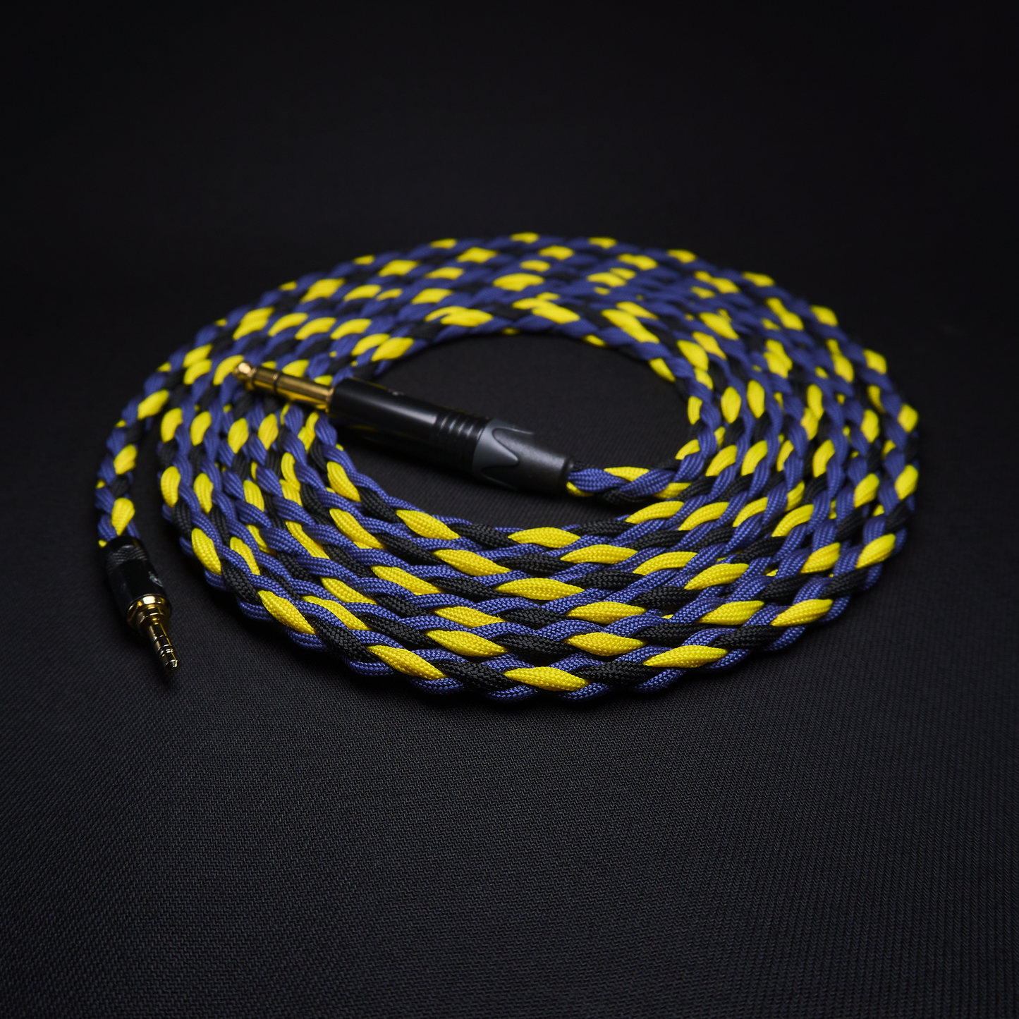Braided blue and yellow audio cable on a black background