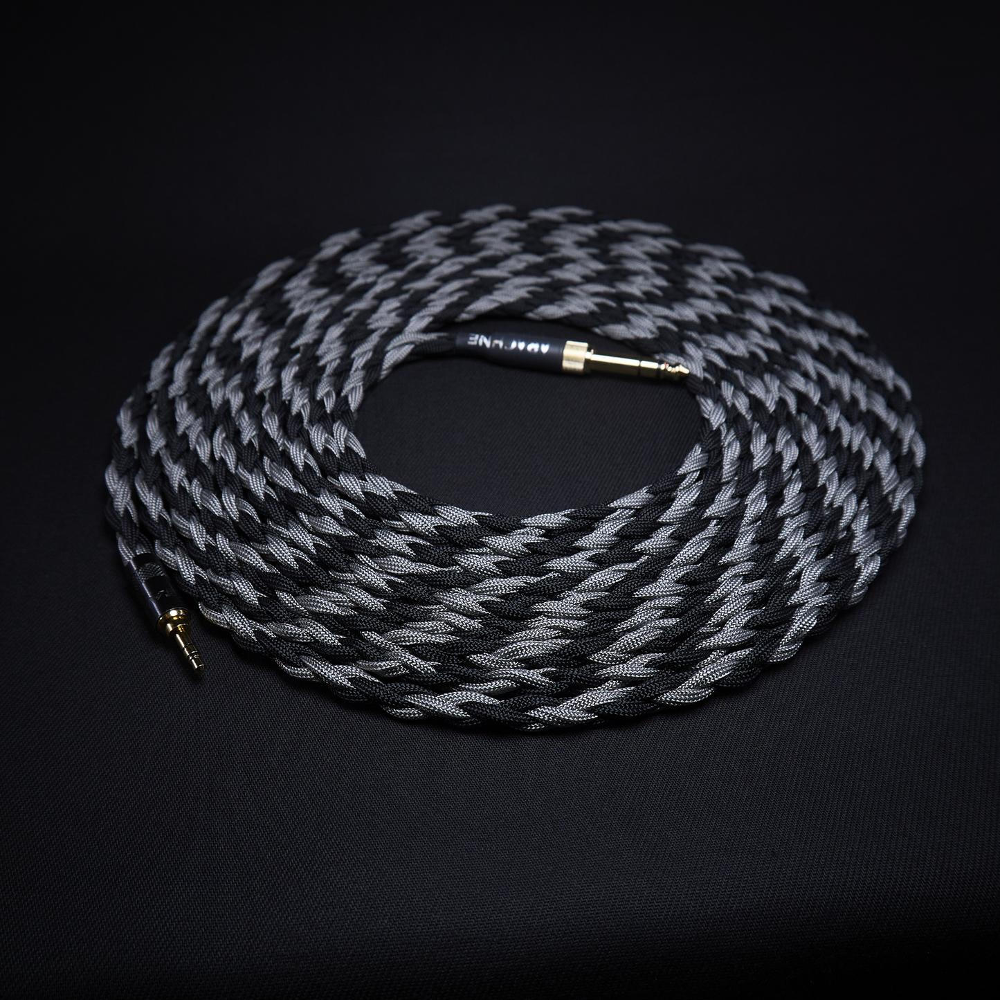 Coiled audio cable with braided design on a black background