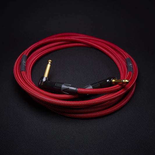 Red guitar cable with gold connectors on a black background