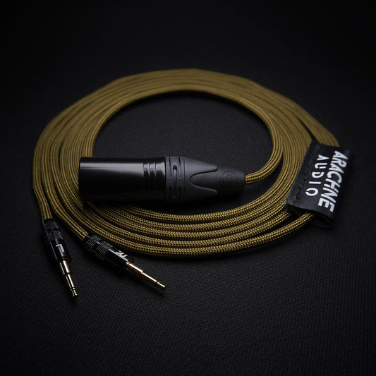 Coiled audio cable with black connector on a dark background, featuring the brand 'Arachne Audio'.