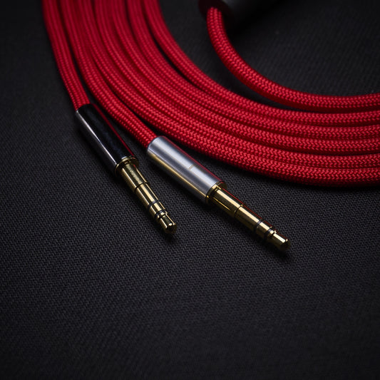 Red braided audio cable with gold and silver connectors on a black background