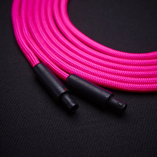 Pink braided cable with black connectors on a dark background