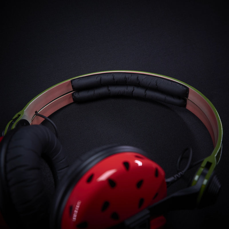 Close up of custom Sennheiser HD25 headphones with unique watermelon-themed hand-painted design, red earcups, green headband, and red audio cable. 