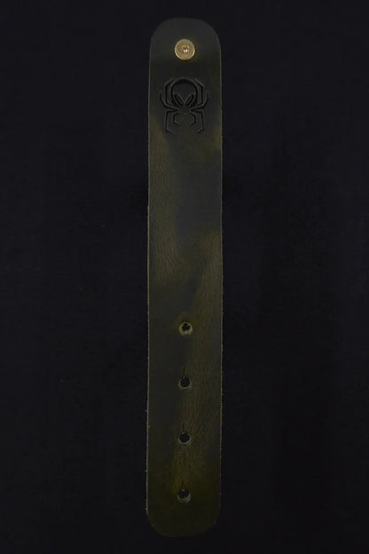 Fermata leather cable strap in Fir (dark green) with brass stud and embossed Arachne spider