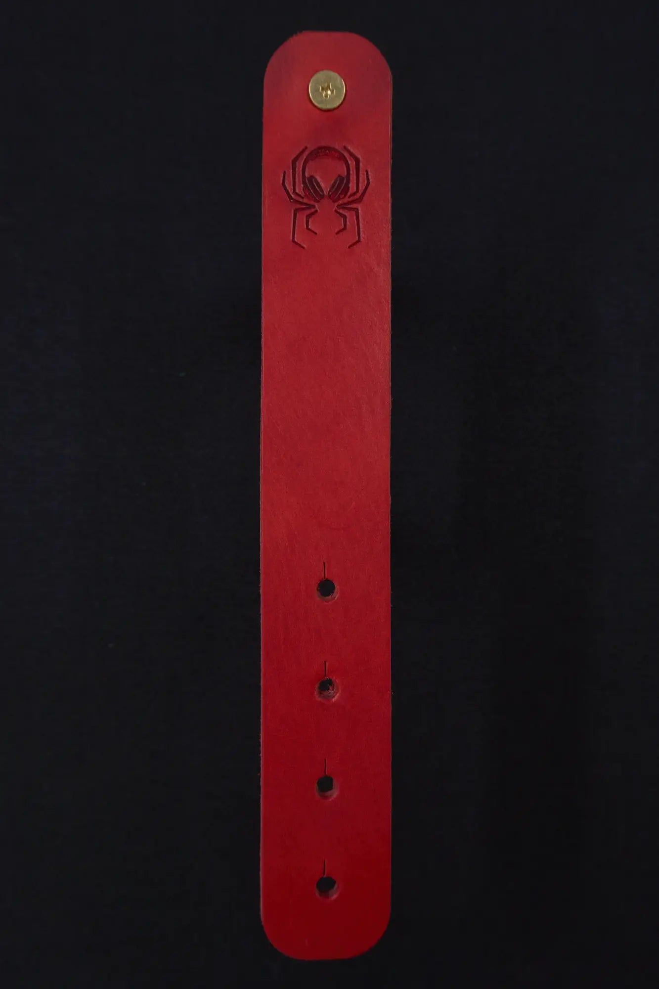 Fermata leather cable strap in Oxblood (red) with brass stud and embossed Arachne spider