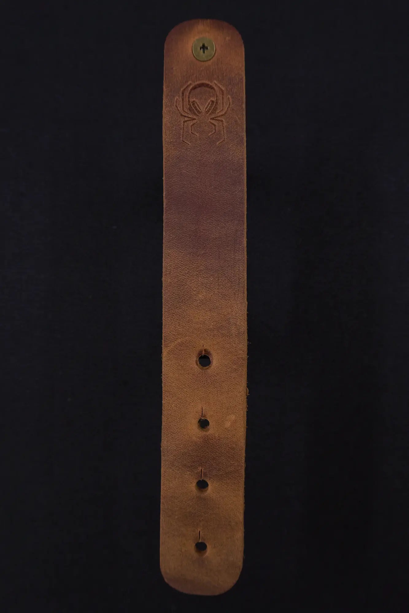 Fermata leather cable strap in Sienna (light brown) with brass stud and embossed Arachne spider