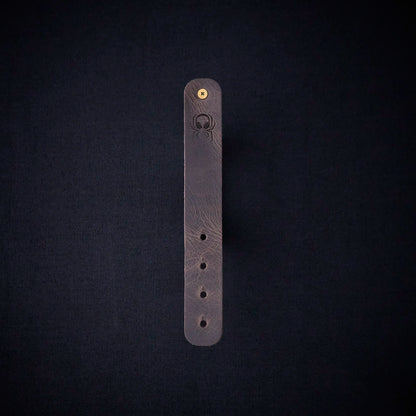 Fermata leather cable organizer in Graphite (grey) with brass stud and embossed Arachne spider