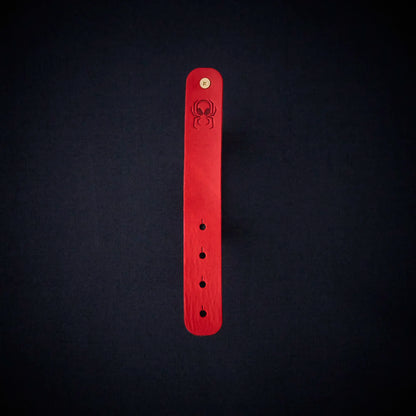 Fermata leather cable organizer in Oxblood (red) with brass stud and embossed Arachne spider